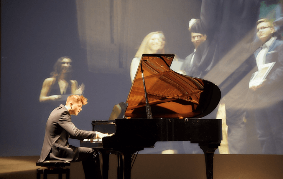 Mateusz Piesiak while is playing the piano during the Awards Ceremony